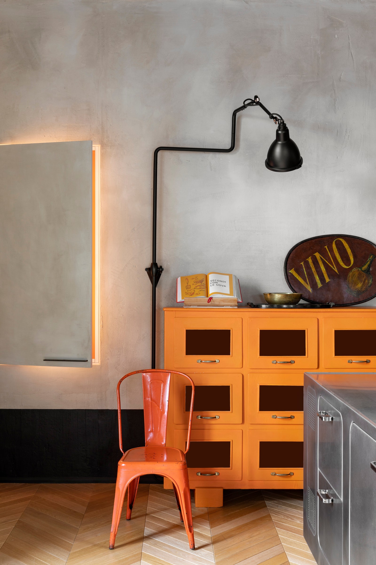 Фрагмент кухни с винтажным комодом перекрашенным в оранжевый цвет. Светильник DCW ditions.