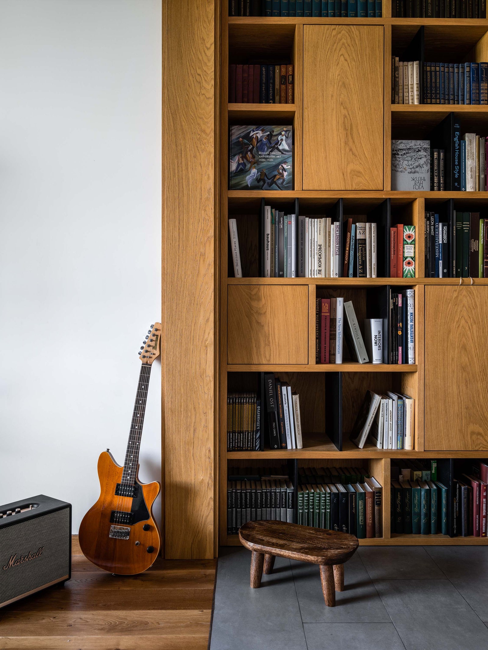 Библиотека выполняет роль места для музицирования — в потолок встроены колонки. Стеллаж сделан на заказ гитара Ibanez...