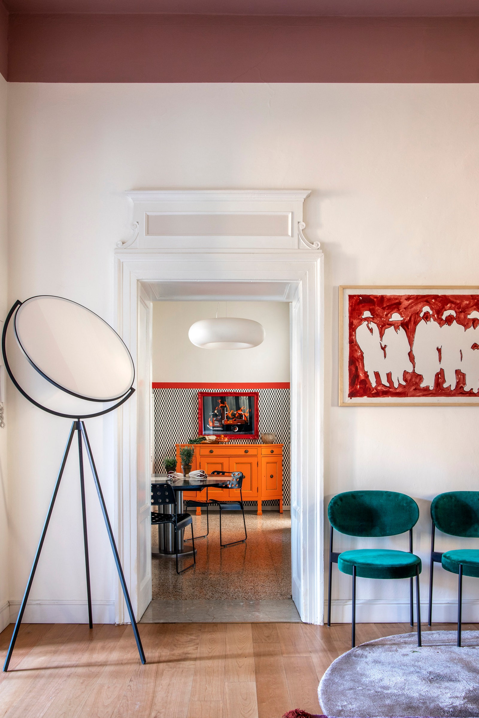 Фрагмент столовой и вид на кухню. Торшер Superloon Flos на стене работа Марио Скифано.