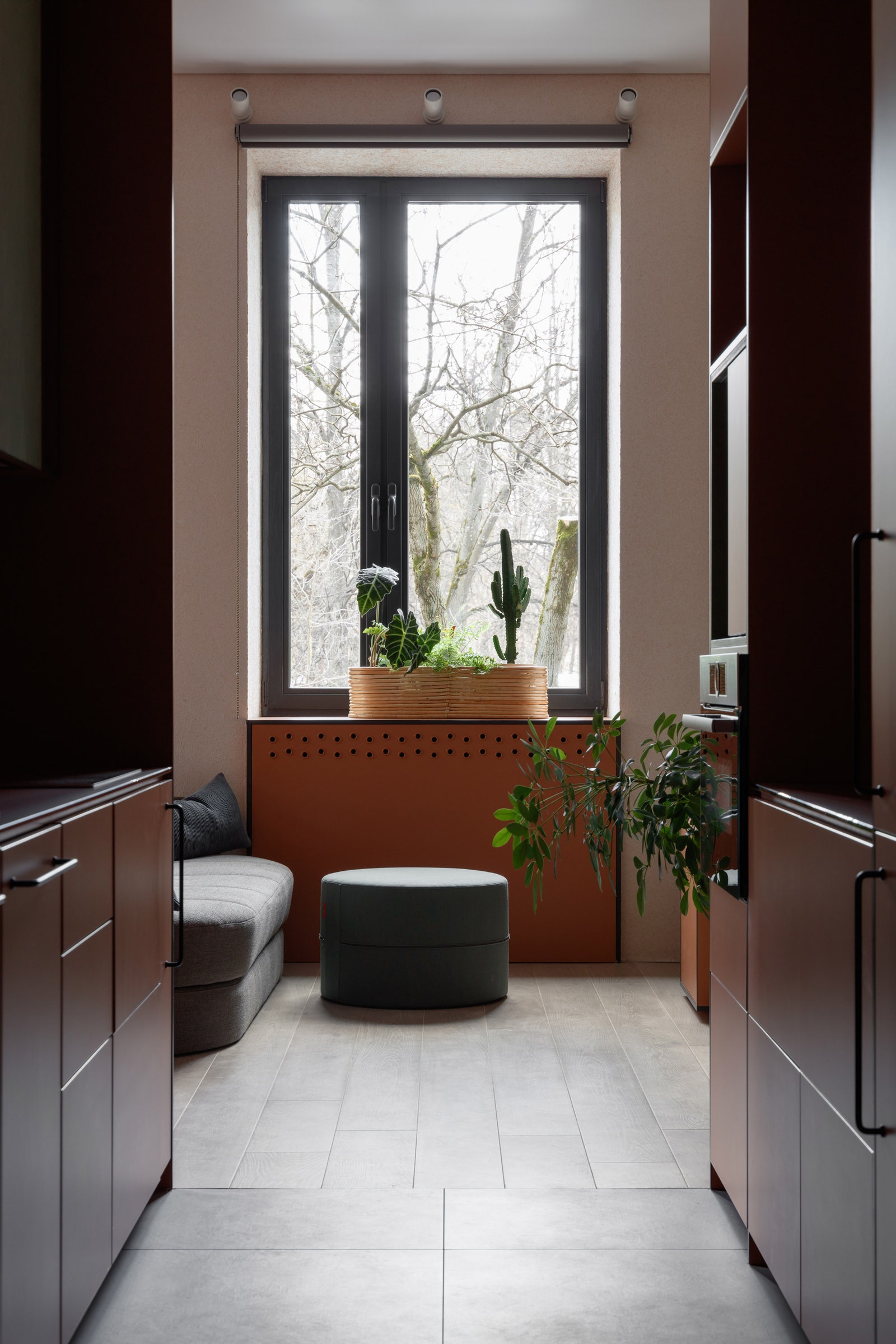 Вид на гостиную из проходной кухни. Диван и пуфик Innovation Living настенные бра над окном IKEA паркетная доска Finex.