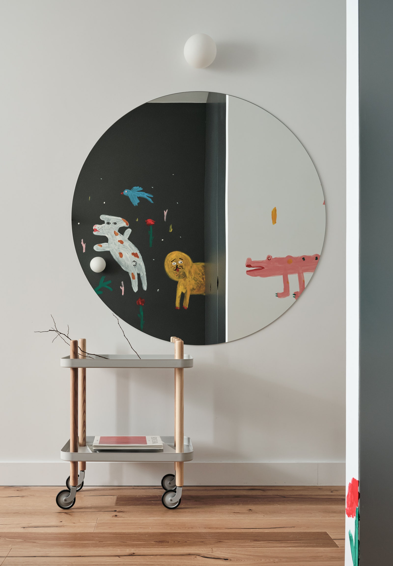 Фрагмент спальни. Столик Normann Copenhagen в круглом зеркале отражается роспись на противоположной стене.
