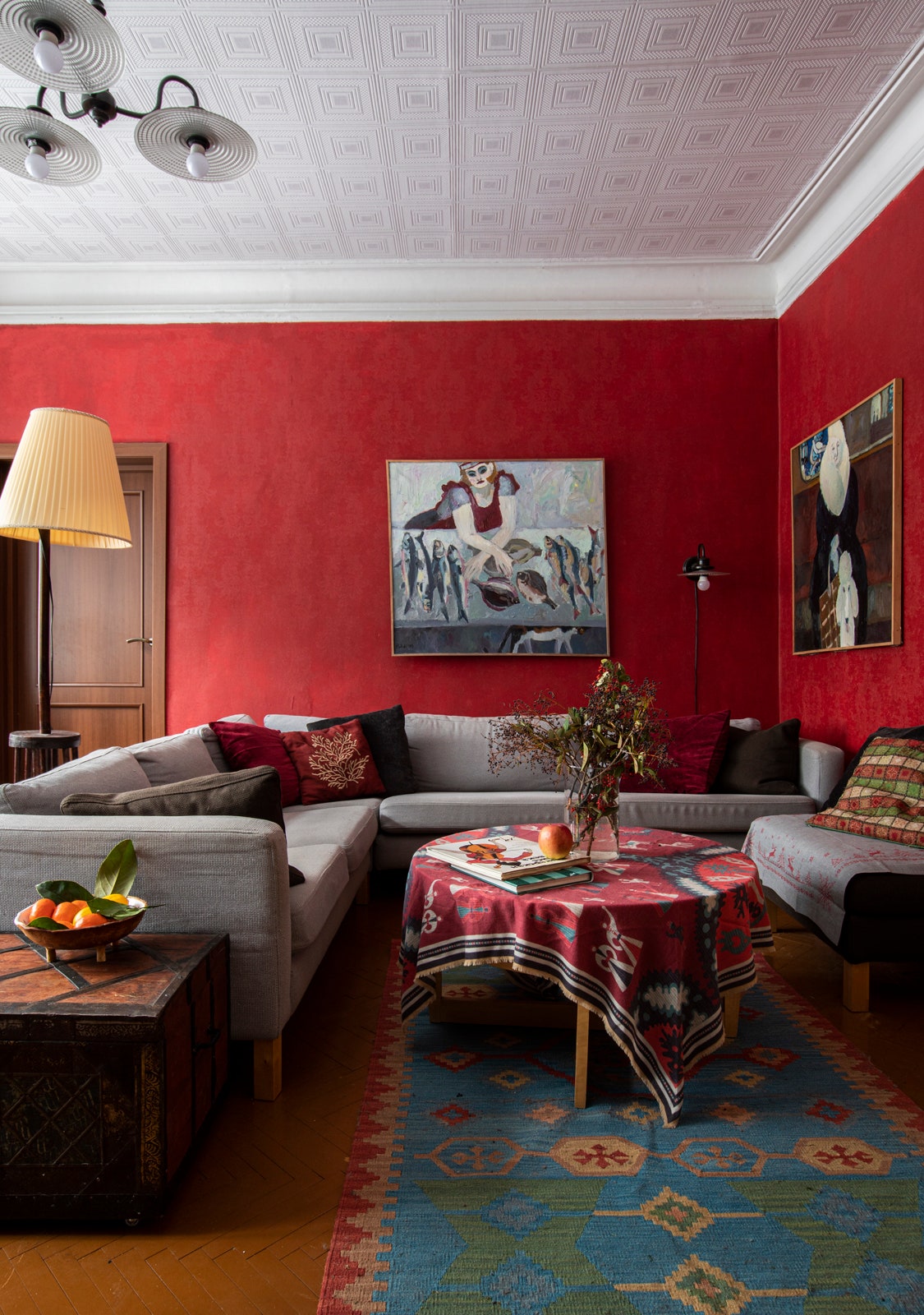 Фрагмент гостиной. Сундук торшер и килим винтажные диван IKEA люстра Natural Concept картины Александры Полиди.