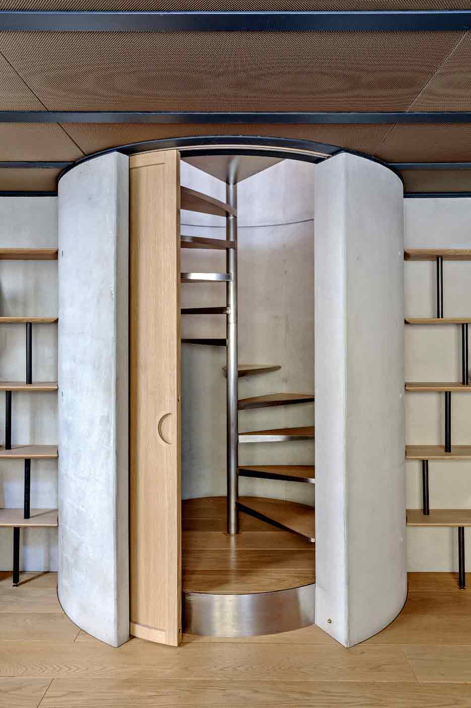 Лестница ведущая на второй уровень спрятана в бетонный “стакан” дверь дизайнер тоже сде­лал полукруглой.