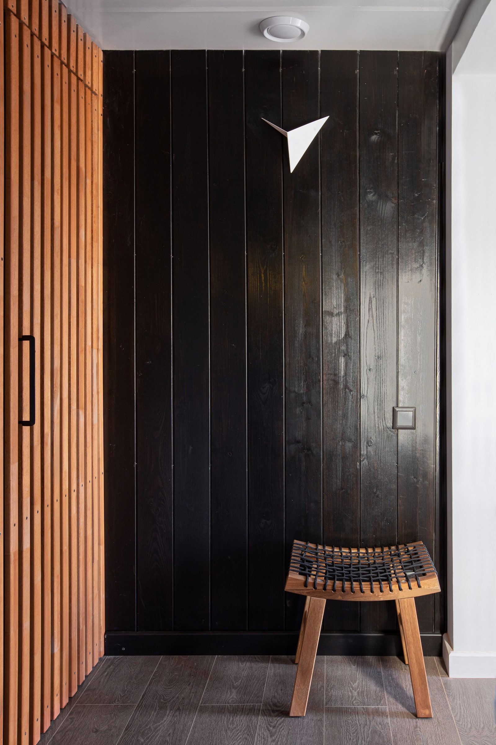 Холл. Скрытая дверь с рейками изготовлена по эскизам автора проекта в мастерской HappyWood. Садовый табурет IKEA.