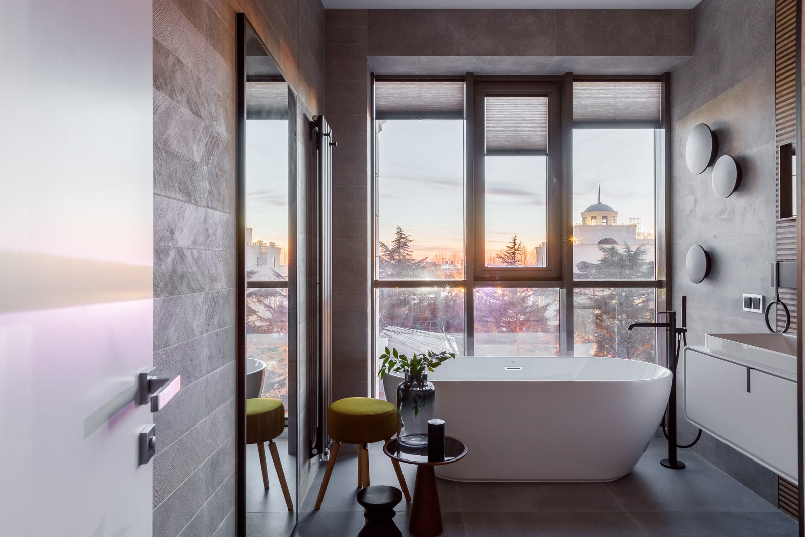 Ванная комната с панорамным окном из которого открывается чудесный вид на город и море.