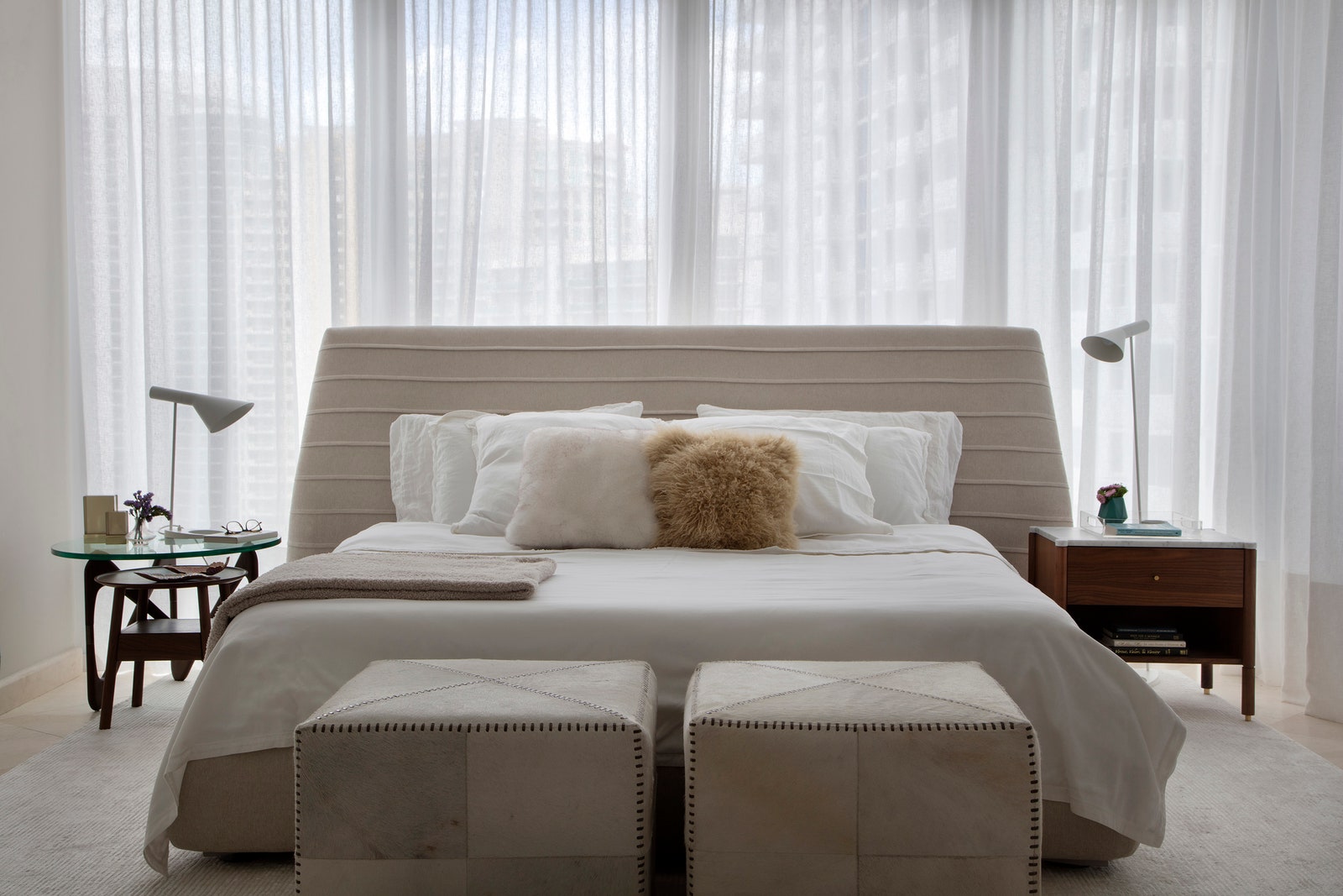 Разные прикроватные тумбочки разбавляют строгость комнаты и придают каждой половине кровати индивидуальности.