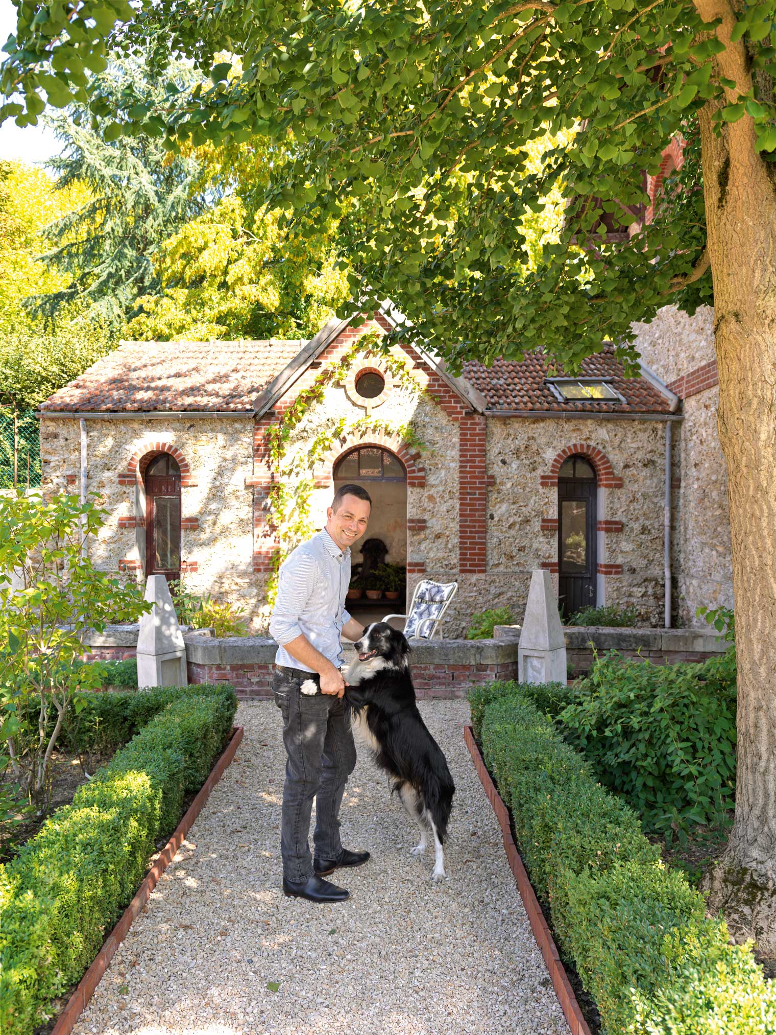 Пьер Гоналон со своей собакой Джино в саду.