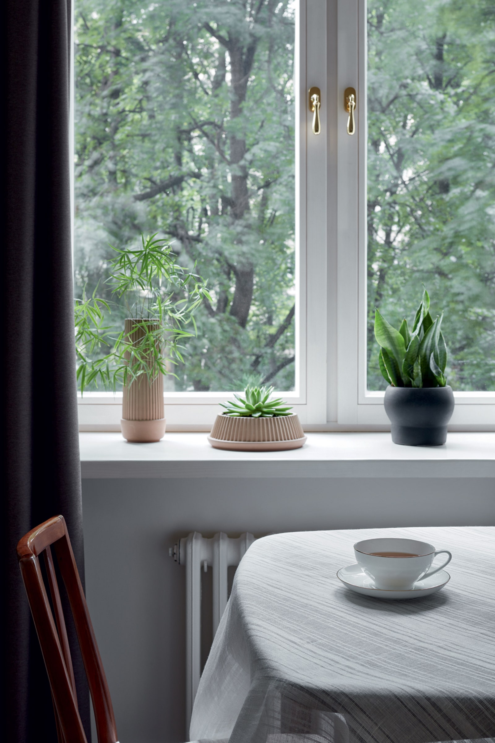 Фрагмент кухни. Деревянные окна “БиТри” кашпо IKEA на столе скатерть изо льна фарфоровая чайная пара ЛФЗ.