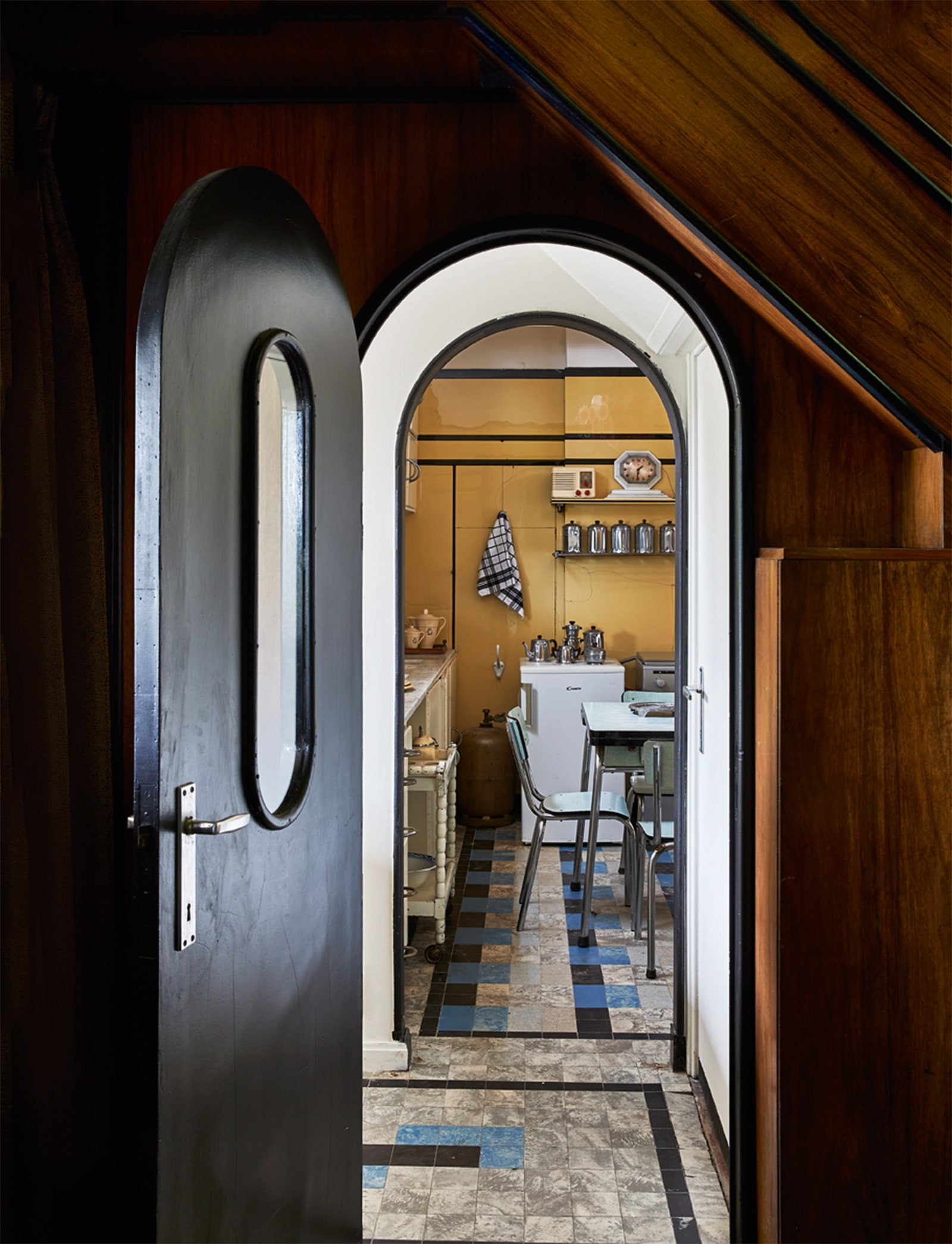 Вид из лестничного холла на кухню где сохраналась ориги­нальная плитка из марблита и мебель марки Cubex.
