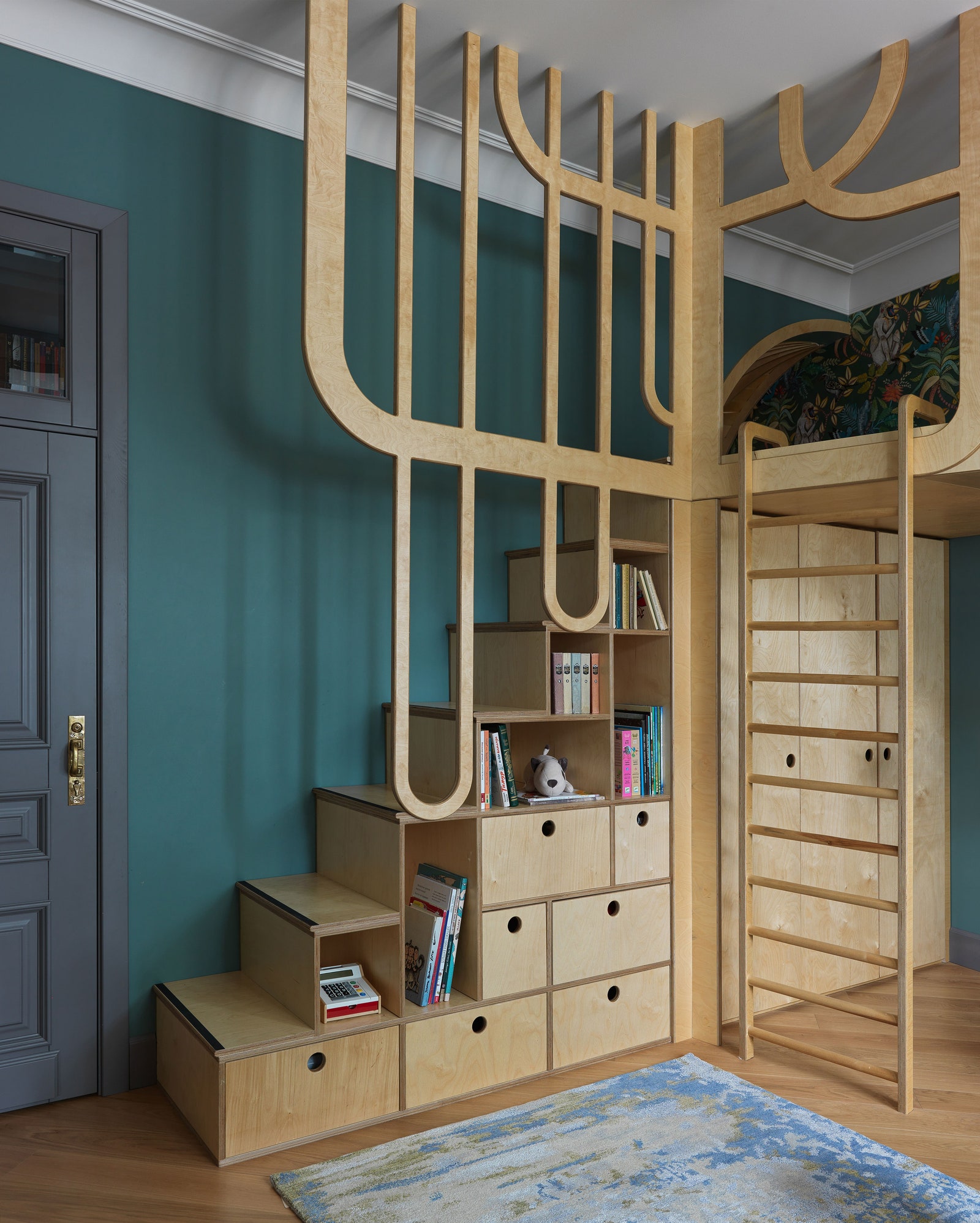 Игровая. Встроенные шкафы лестница и ее огражде­ние в виде стилизованного дерева сделаны на заказ по эскизам дизайнеров...