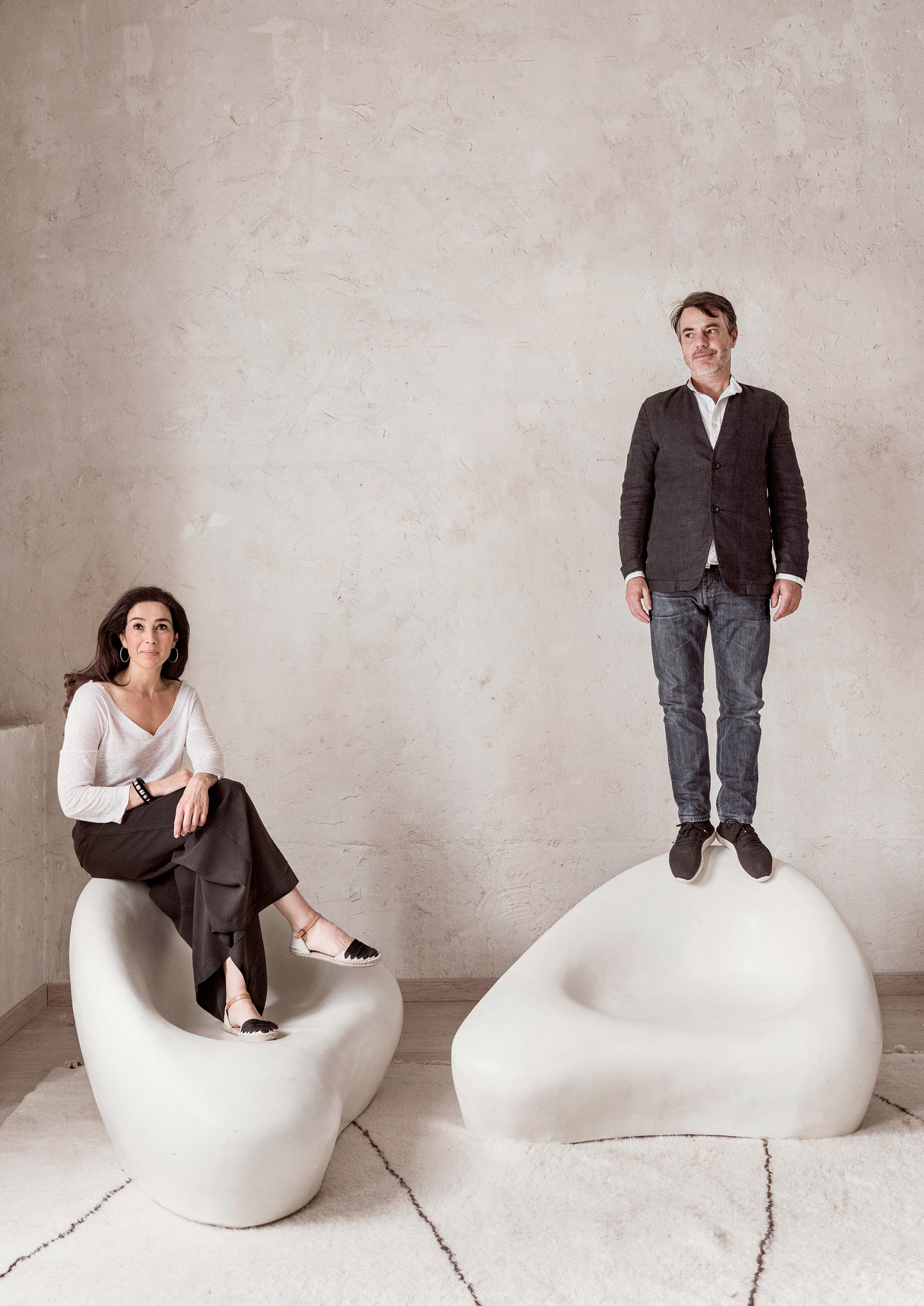 Кристина ЛопесБарио и Маноло Ильера позируют на винтажных диванах из галереи декоратора Сержа Кастеллы.