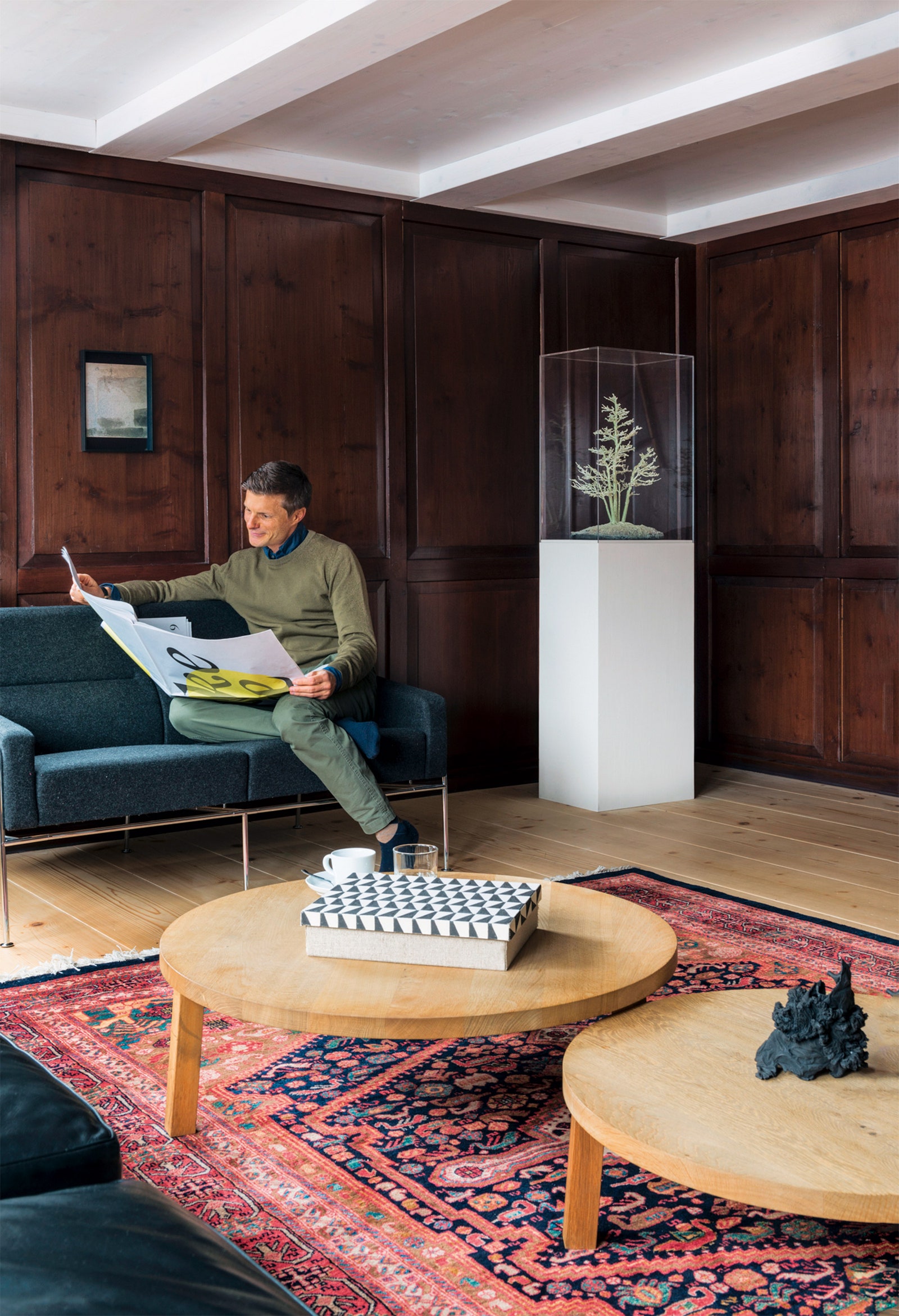 Хозяин дома Стефан Ломбарди на диване по дизайну Арне Якобсена на стене работа Гауденца Синьорелля справа скульп­тура...