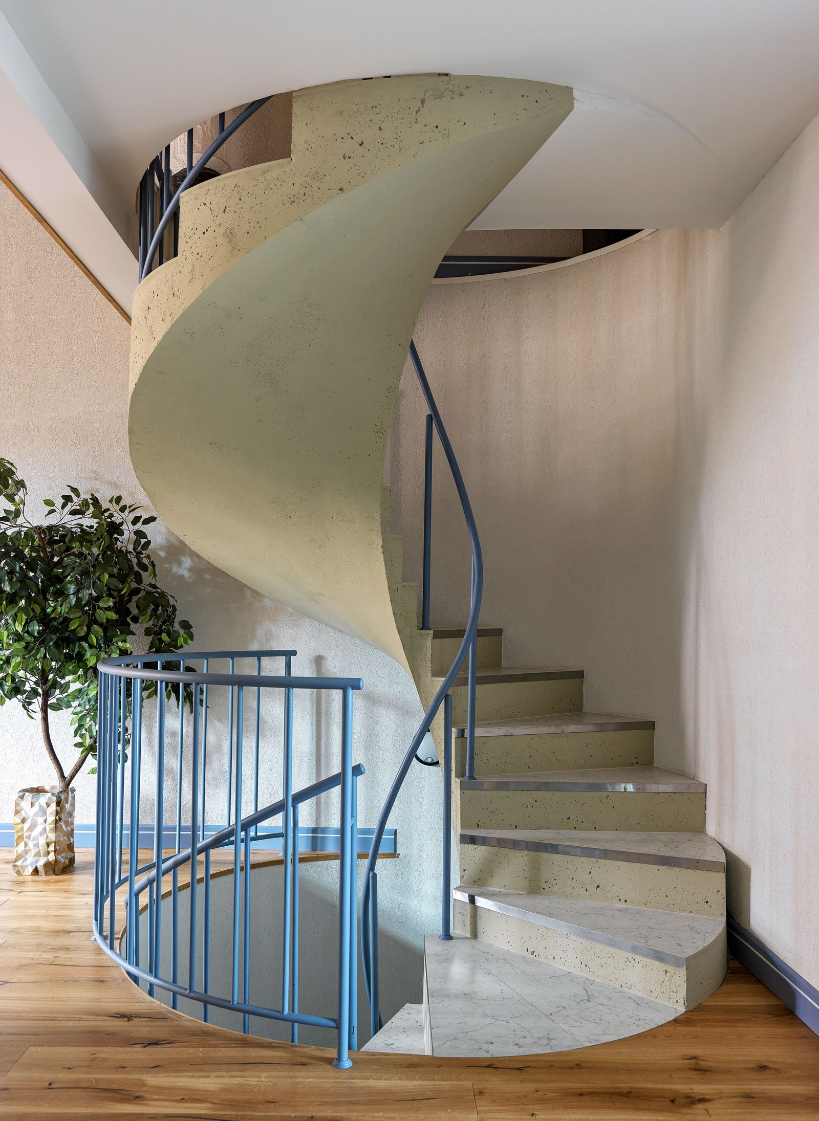 Винтовая лестница сделана по эскизам дизайнера в компании “Мастерия”. Ступени отделаны керамогранитом Kerama Marazzi.