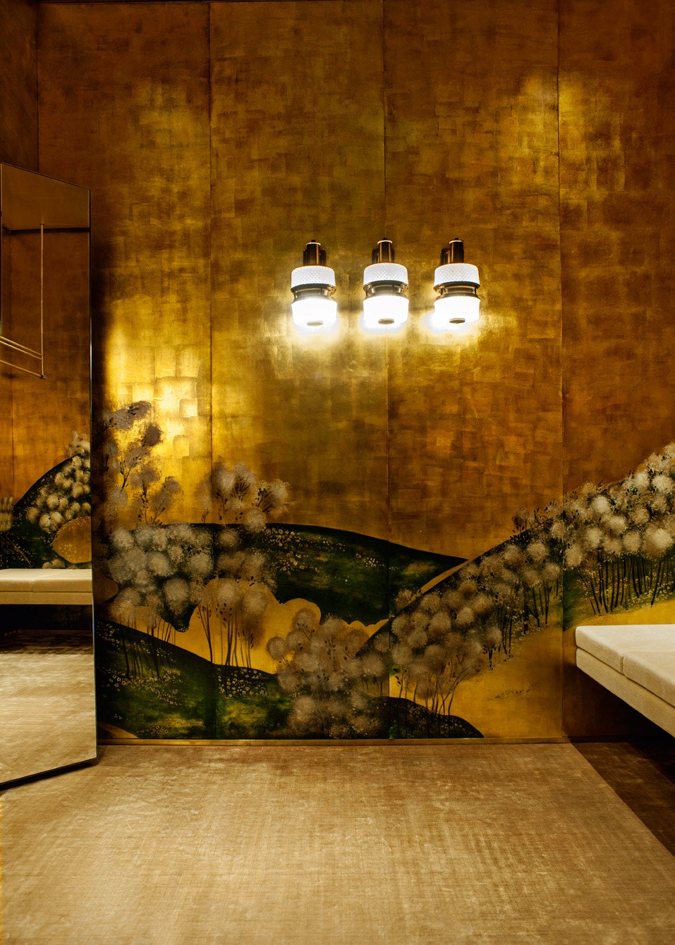 Стены при­мерочных отде­ланы золотистыми панелями на которых изображены пейзажи в китайском стиле.