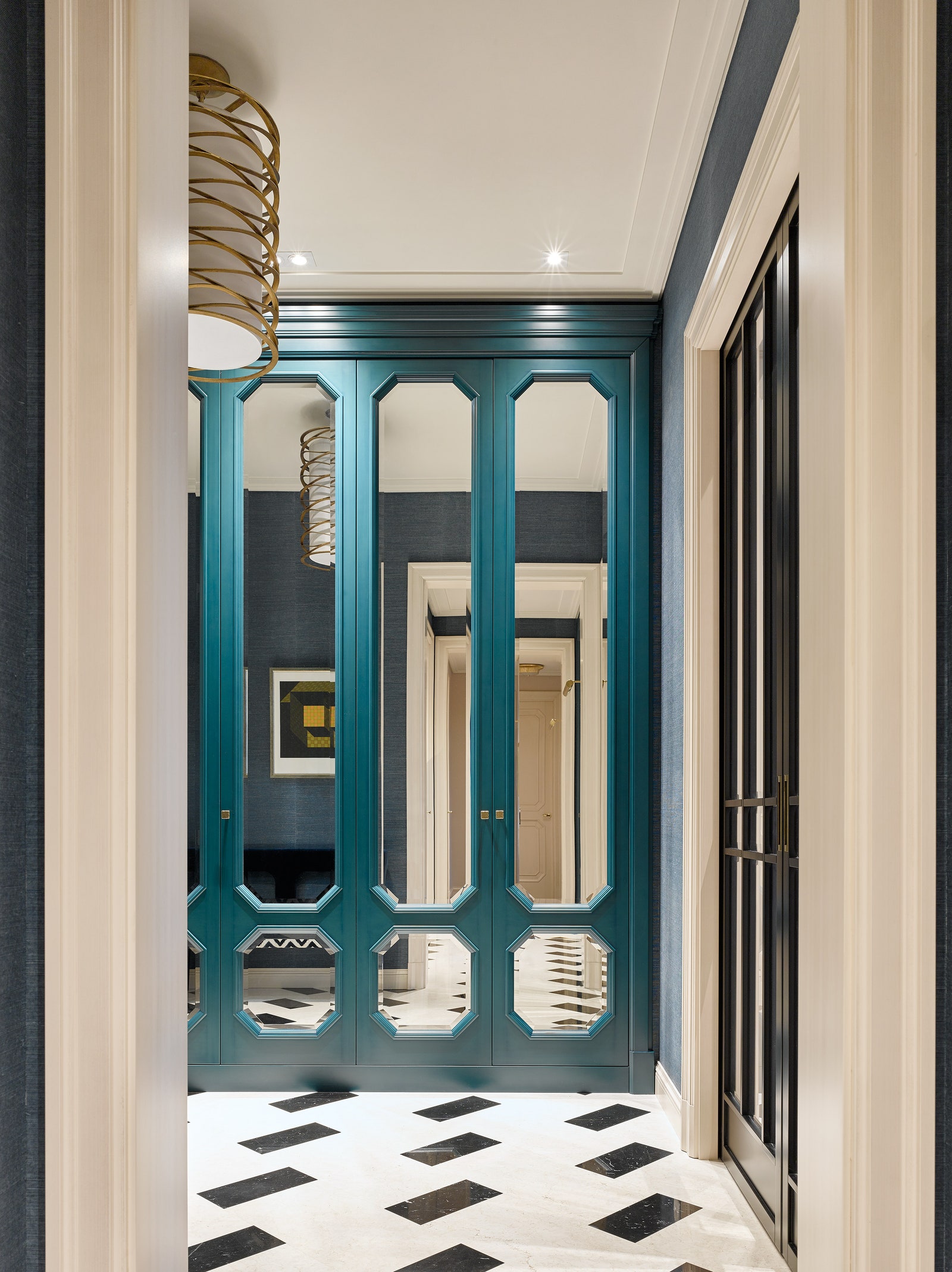 Встроенные шкафы и раздвижные двери в прихожей сделаны на заказ. Мраморный пол SLC. Светильник Visual Comfort amp Co.