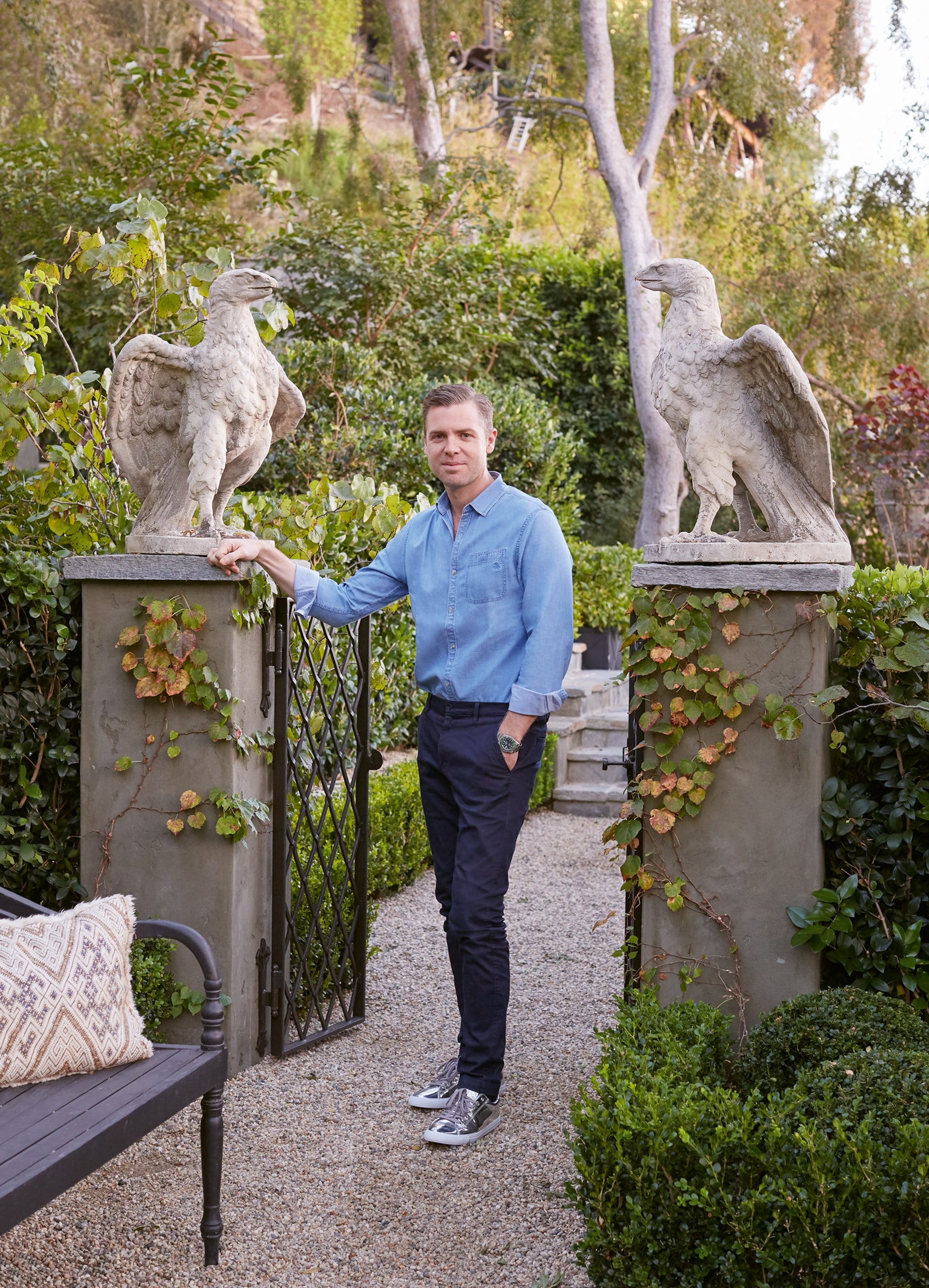 ЖанЛуи Денио в саду своего лосанджелесского дома. Антикварные статуи орлов приехали сюда из Франции.