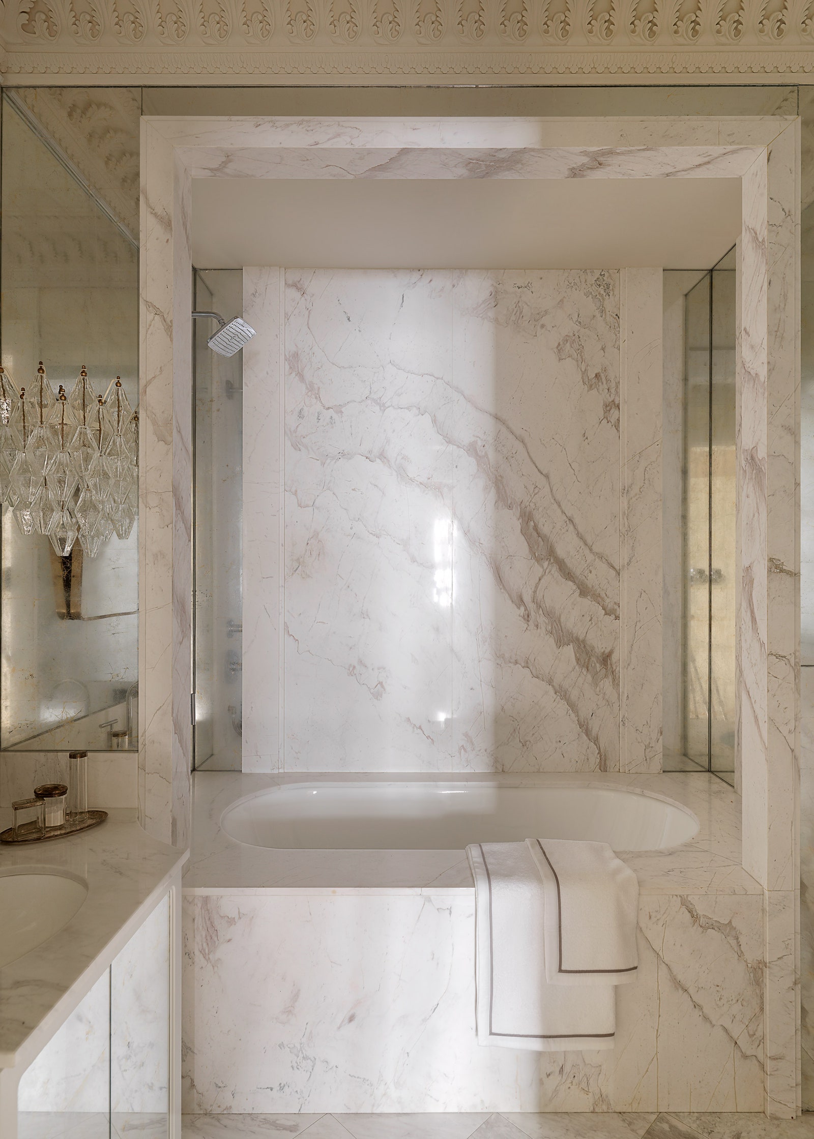 Стены ванной облицованы мрамором волокас и патинированным зеркалом светильники по дизайну Карло Скарпы.