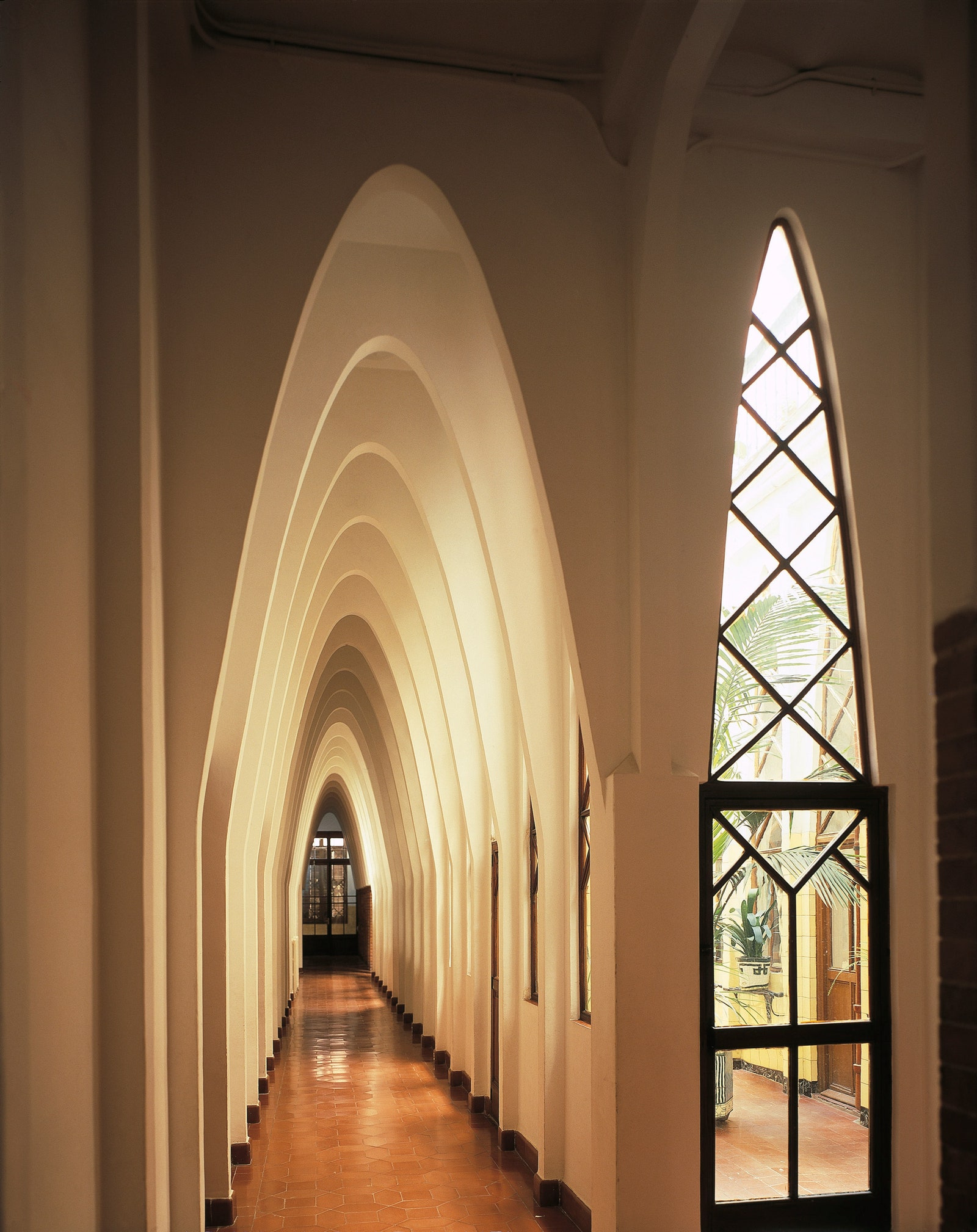 Коридор первого этажа с параболическими арками школа при монастыре Святой Терезы в Барселоне. Архитектор Антонио Гауди.