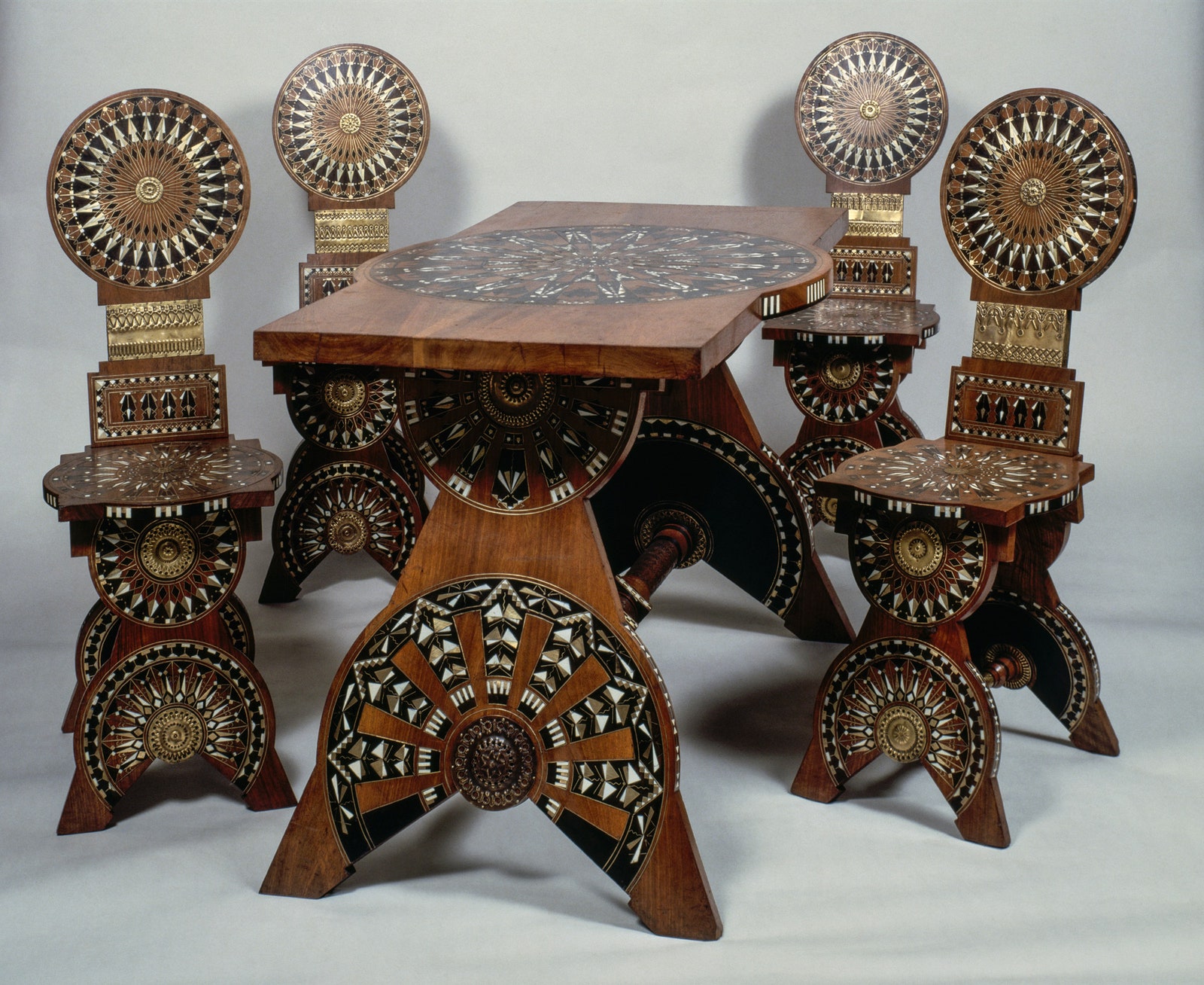 Стол из орехового дерева и четыре стула украшенные инкрустациями из слоновой кости и металла 1898 дизайнер Карло Бугатти...
