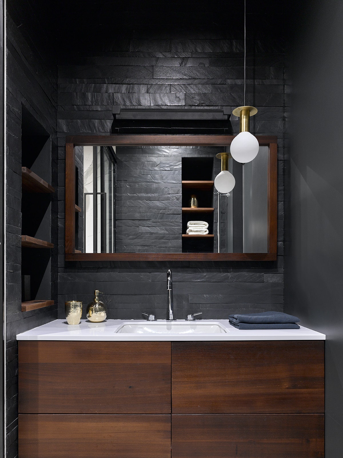 Ванная комната. Тумба и зеркало Interior Elements стены отделаны черным сланцем.