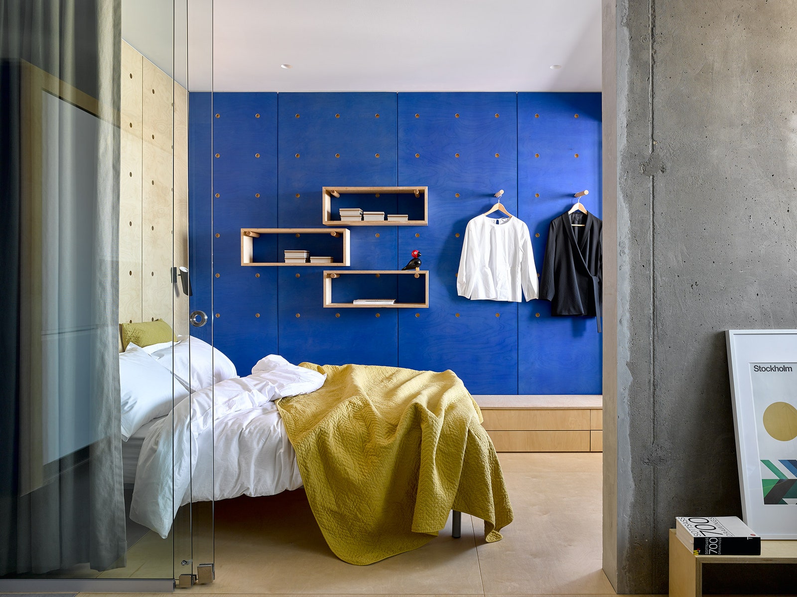 В спальне из фанеры сделаны настенные панели с круглыми просверленными отверстиями. В них вставляются деревянные штыри...