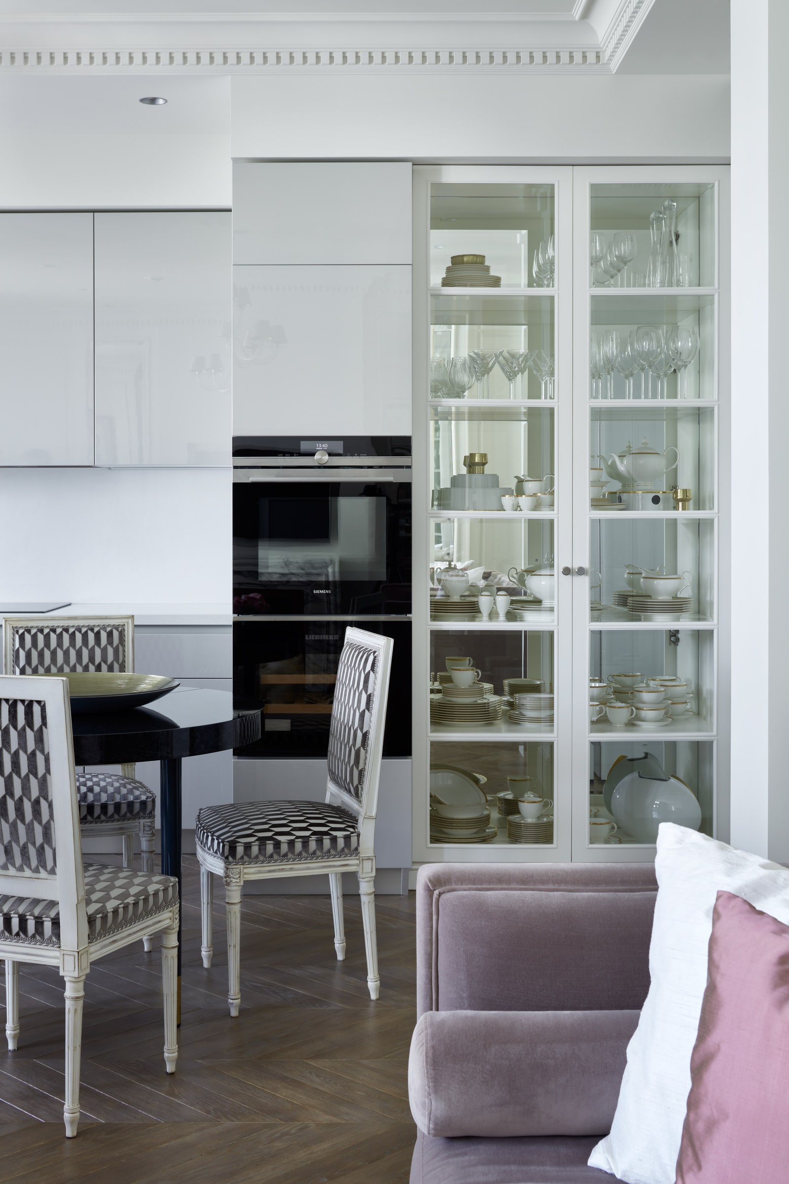 Фрагмент кухни. Кухня Scavolini классические стулья обиты современной тканью с чернобелым принтом витрина изготовлена на...