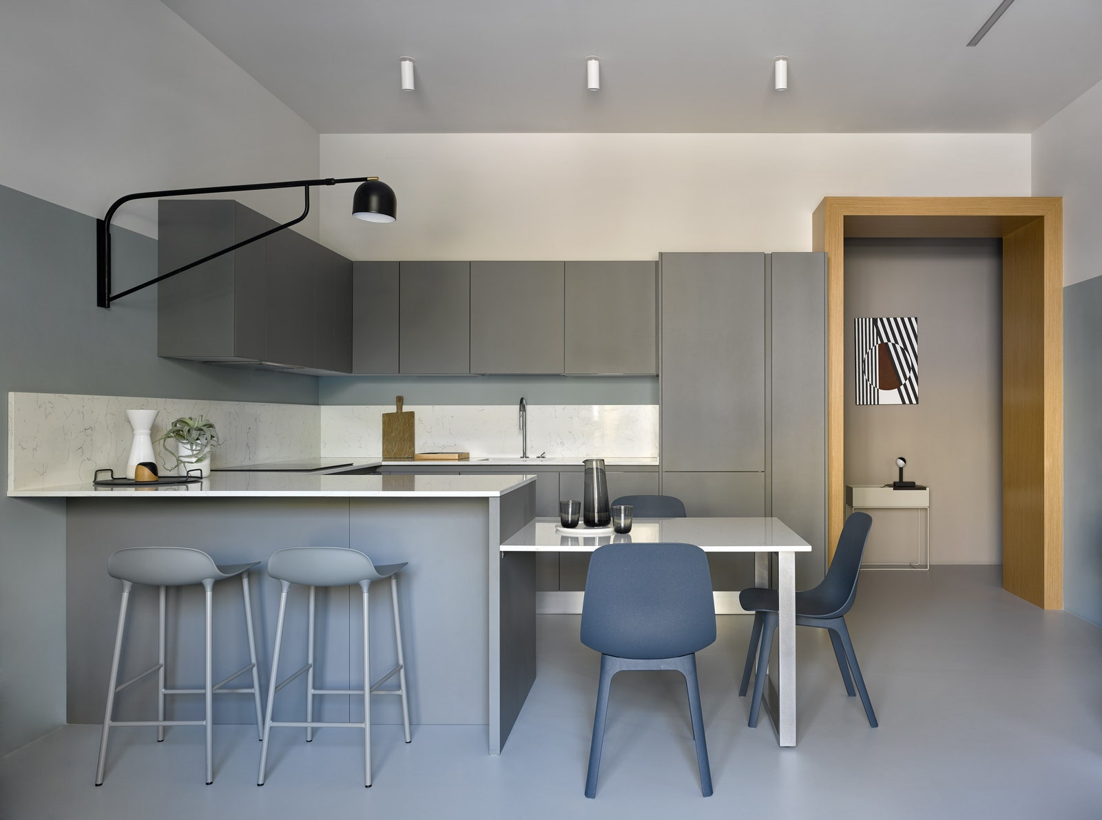 Вид на кухню из зоны гостиной. Стулья по дизайну Hay для IKEA барные стулья Normann Copenhagen светильник Bellman Pholc.