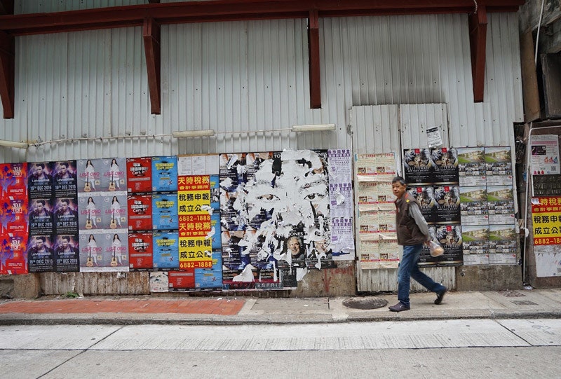 Работа на стене с рекламными плакатами. Гонконг 2016 год. Фотограф José Pando Lucas.