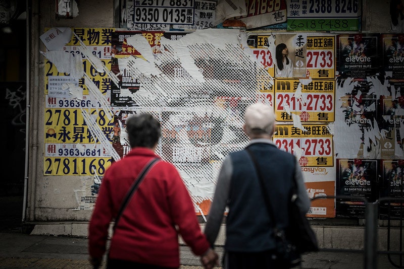 Работа на стене с рекламными плакатами. Гонконг 2016 год. Фотограф José Pando Lucas.