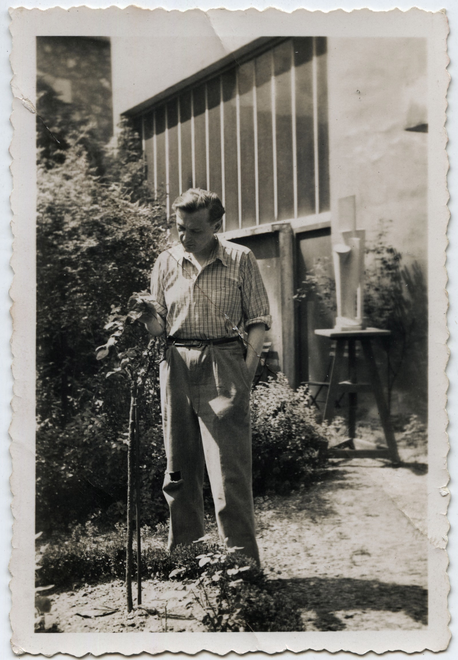 Жак Липшиц в саду своего домамастерской в БулоньсюрСен. За ним — каменная скульптура . Около 1926. Музей искусства и...