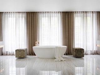 Хозяйская ванная комната. Ванна из цельного мрамора Bianco Dolomiiti. Пуфы по дизайну Наталии Мияр обтянуты тканью Fortuny.