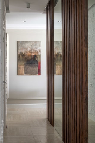 Палисандровые панели кирпич и зеркала «разбивают» коридор.