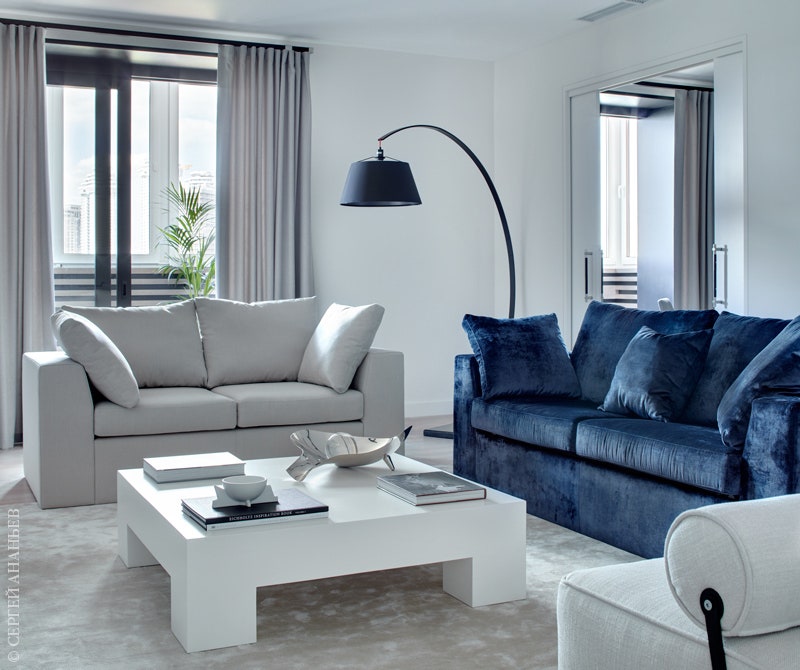 На полу в гостиной ковер Dovlet House. Синий диван — единственный яркий акцент в этом чернобелом пространстве.