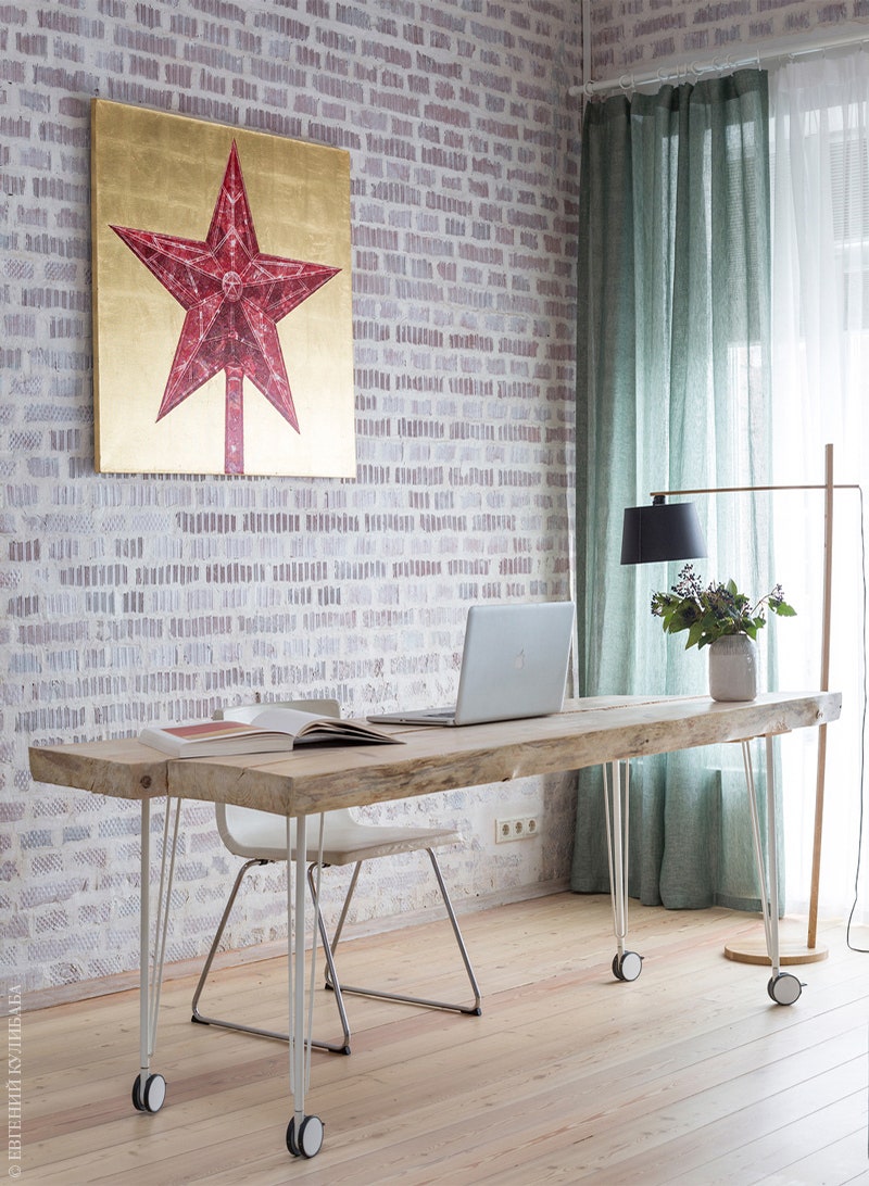 Гостиная выполняет также роль домашнего кабинета. Рабочий стол сделан на заказ. На стене работа Алексея БеляеваГинтовта.