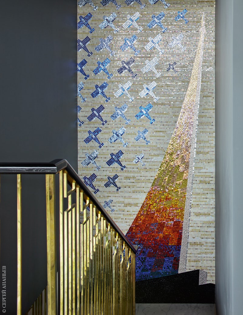 Лестницу украшает масштабное мозаичное панно по дизайну Ольги Солдатовой на тему монумента Покорителям Космоса в Москве.