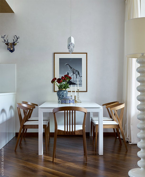В зоне столовой стол и стулья Сalligaris. Светильник Masiero. На стене фотография фотография Мишеля Компте.