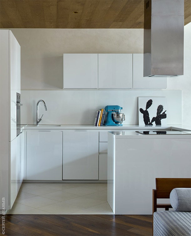 Граница кухни и гостиной обозначена с помощью напольного покрытия. Кухонный гарнитур Spagnol.