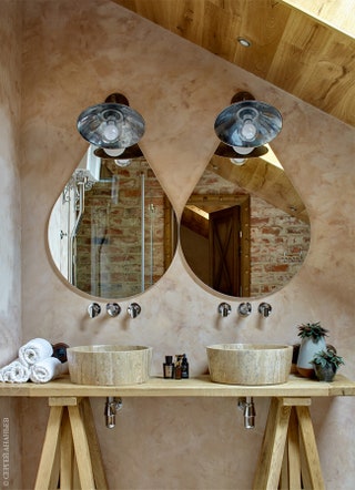 Фрагмент ванной комнаты в мансарде. Зеркала Drop Calligaris. Раковины из травертина и подстолье в виде верстака...