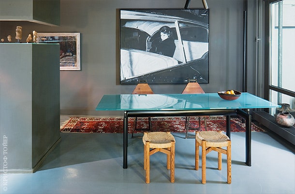 Столовая. Стол по дизайну Ле Корбюзье табуреты по дизайну Шарлотты Перриан. Слева за перегородкой находится кухня.