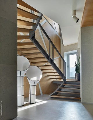 Лестница на второй этаж. Ступени и геометрические панели на стенах сделаны из корня ясеня. Софит Vibia. Торшеры Designheure.