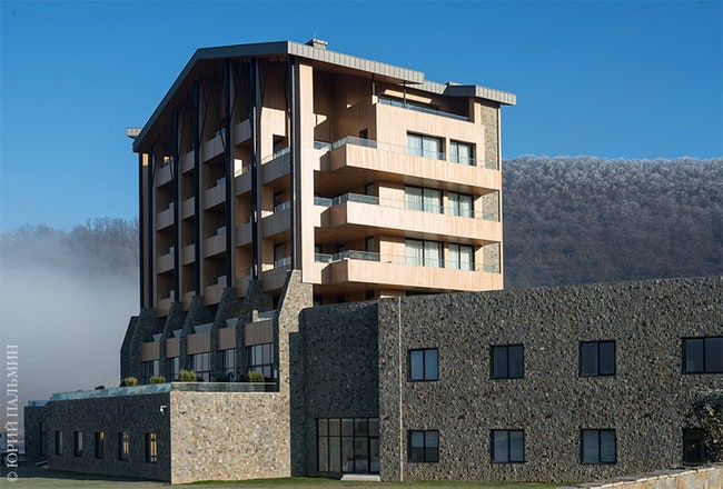 Отель расположен в живописной местности между горами и озером.
