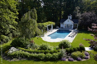 Вид из главного дома на бассейн и гостевой дом — а также на цветы которые клиенты обожают.