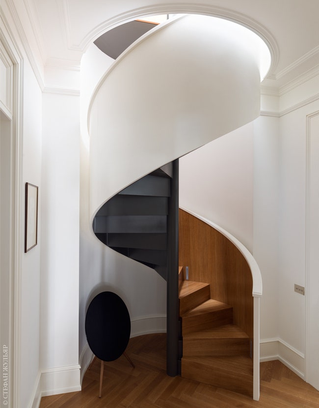 Два этажа квартиры соединяет скульптурная винтовая лестница состоящая из трех “слоев” — черный металл дерево и белая...