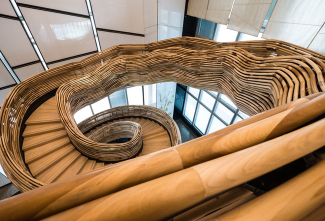 Деревянная лестница в виде торнадо в офисе в башне Amot Atrium в Израиле | Admagazine