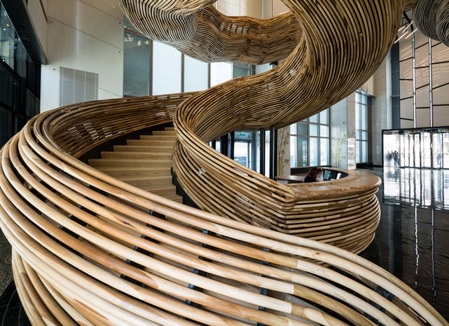 Деревянная лестница в виде торнадо в офисе в башне Amot Atrium в Израиле | Admagazine