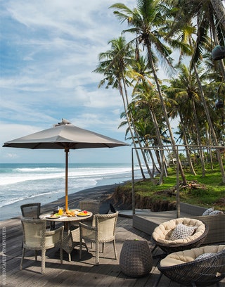 Вилла расположена в редкой для Бали пальмовой роще и окружена пляжами с черным вулканическим песком.