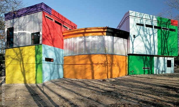 Стены дома сделаны из разноцветных металлических щитов и полупрозрачного поликарбоната.