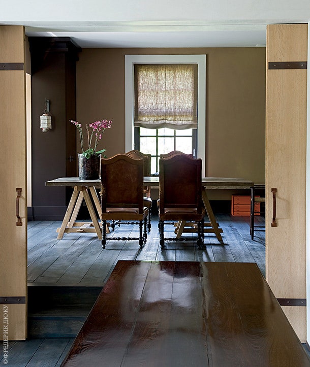 В небольшом салоне рядом с кухней стоит стол найденный в подвале дома и антикварные стулья.