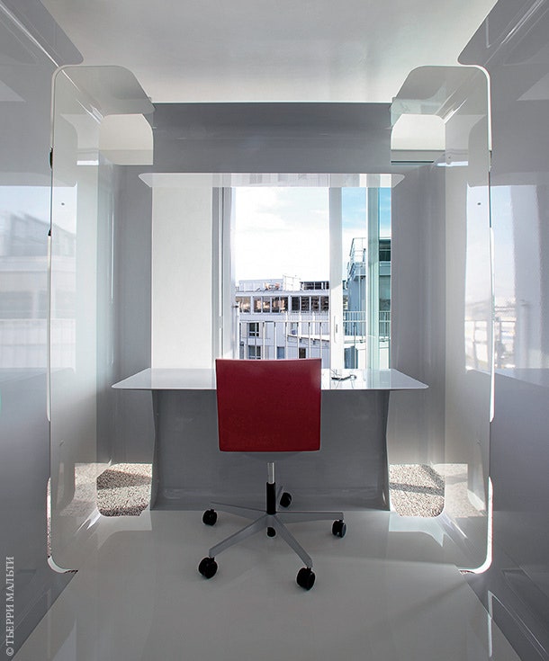 Небольшой рабочий кабинет устроен в кубе из белых металлических листов. Стол из кориана по дизайну архитекторов.