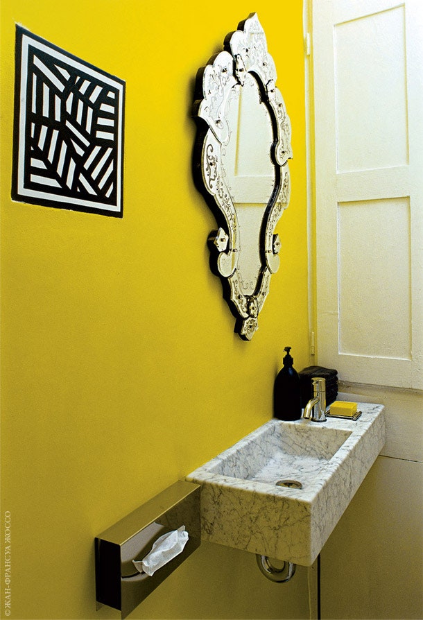 В стену гостевого туалета вмонтирована плитка с рисунком Сола Левитта. Рядом висит зеркало эпохи Наполеона III.